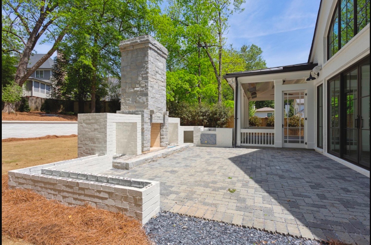 Custom stone outdoor fireplace with large paver patio