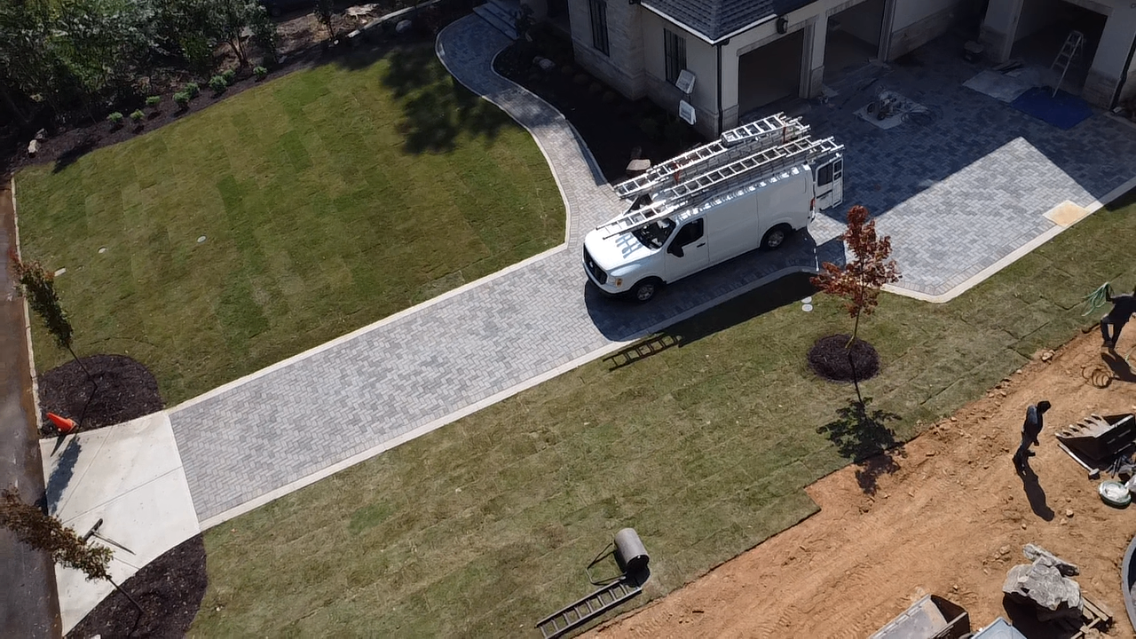 Close aerial view of a paver driveway and curved entry walk