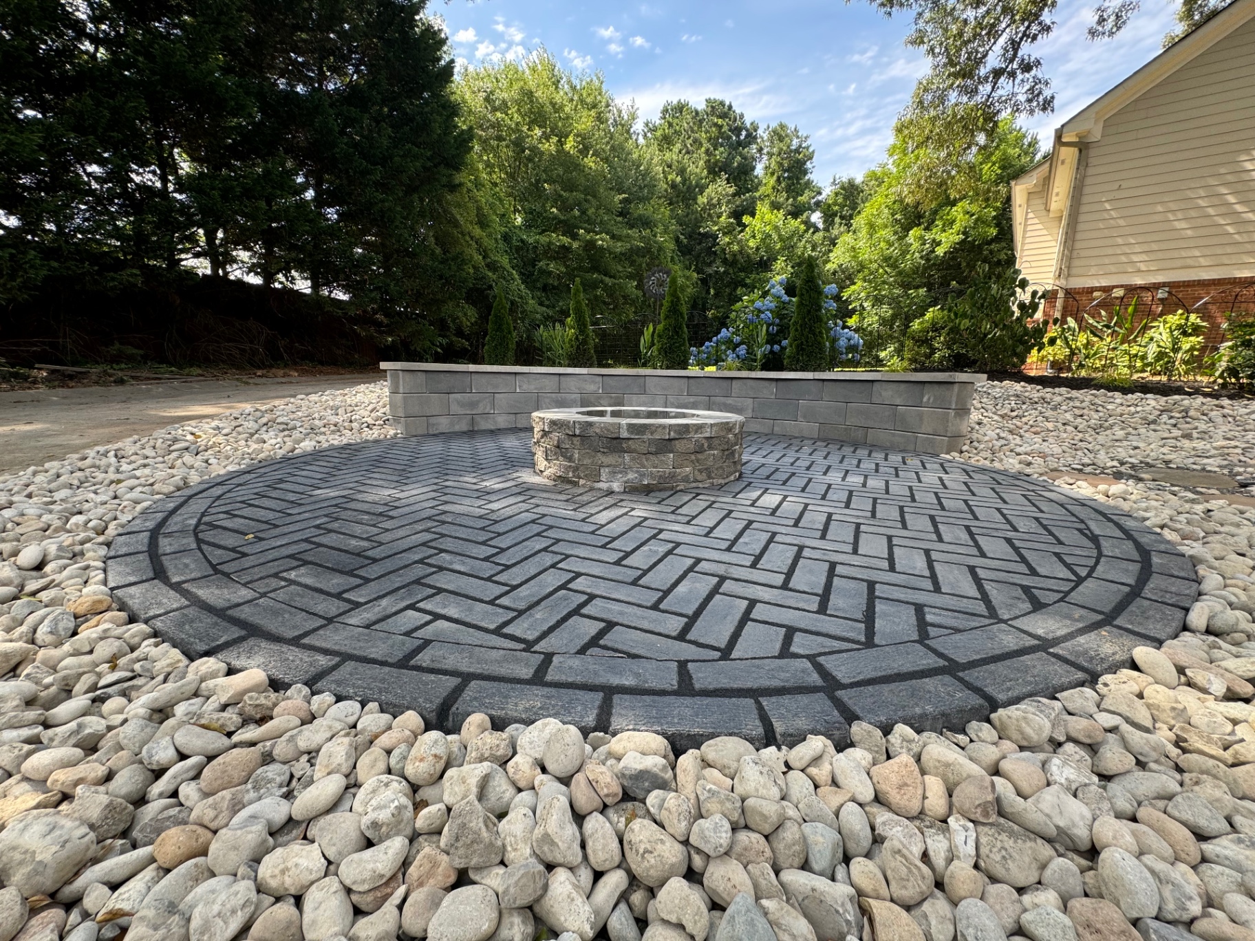 Circular paver fire pit patio with stone seat wall