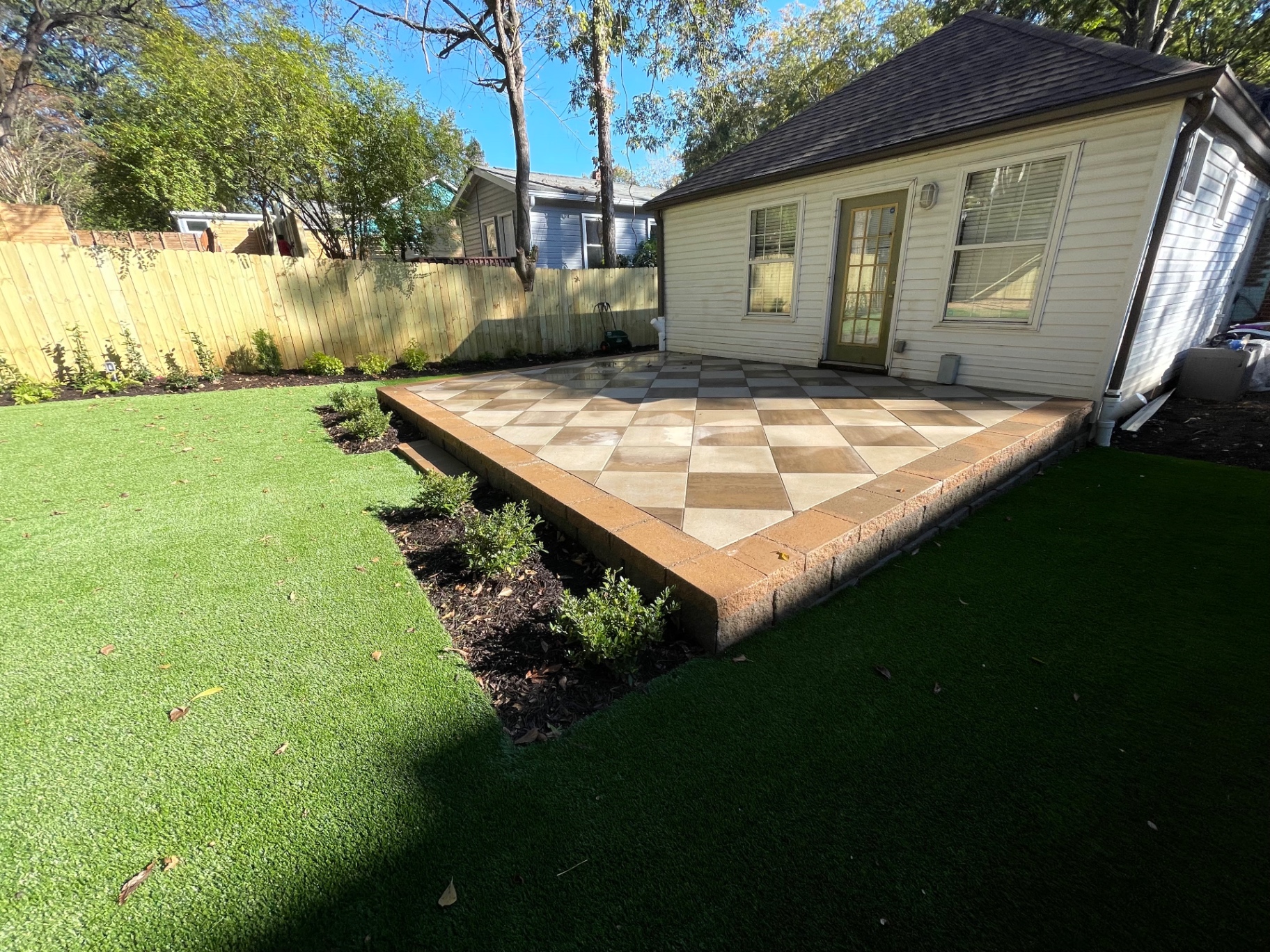 Two-tone checkerboard paver patio with raised garden beds
